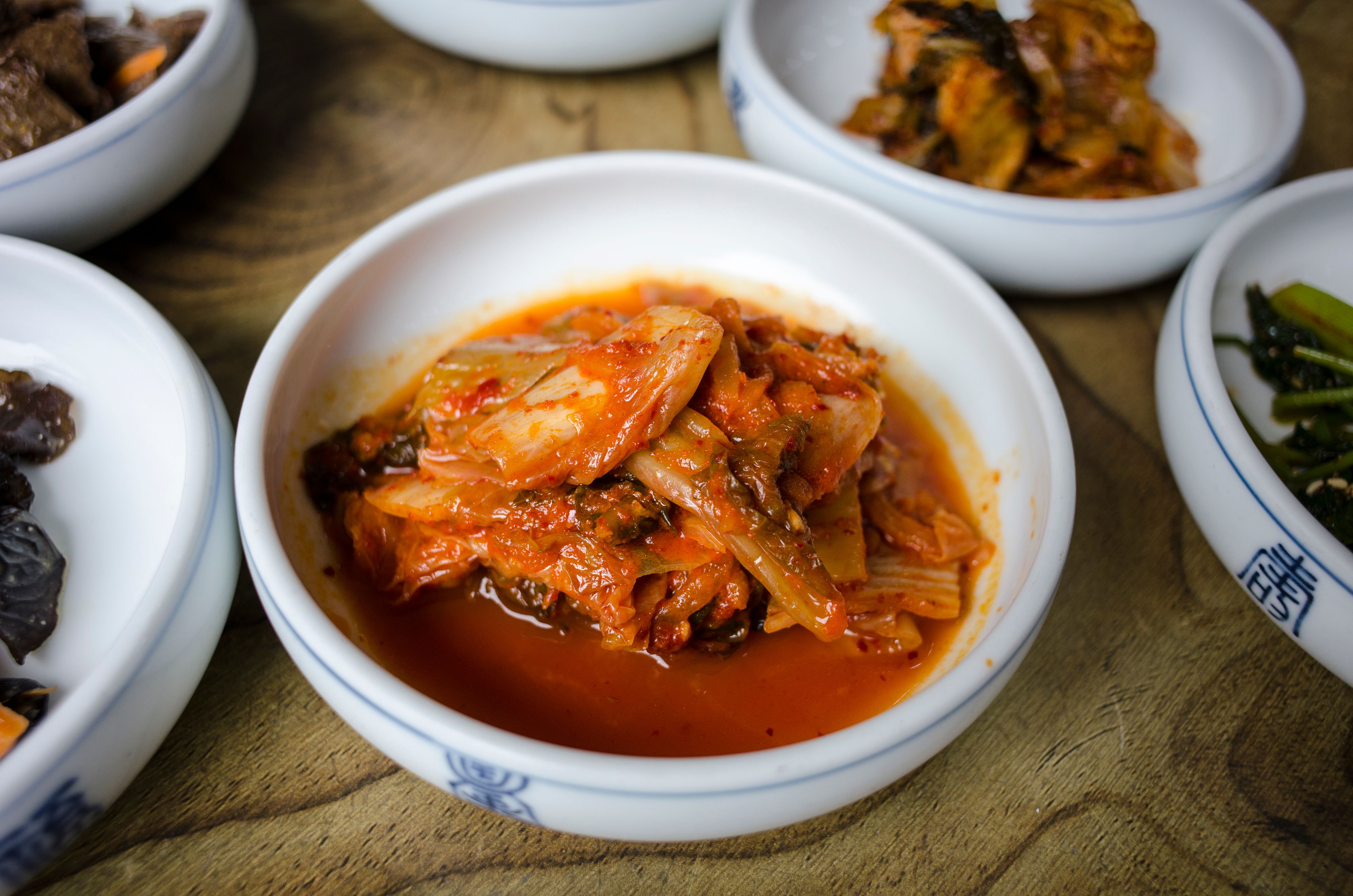 집에서 담근 김치 한 그릇과 프로바이오틱스 요구르트 한 잔, 장 건강을 상징하는 이미지
