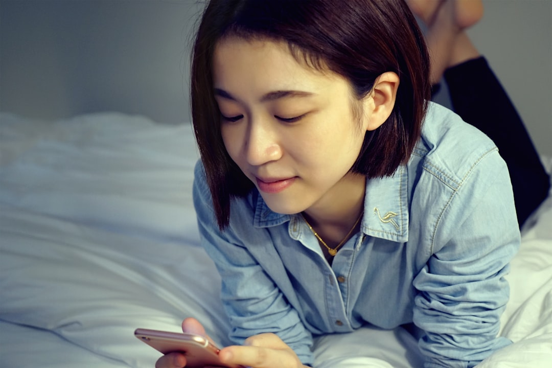 어두운 침실에서 스마트폰을 끄는 사람의 모습, 잠들기 전 전자기기 사용을 멈추는 중요성 강조